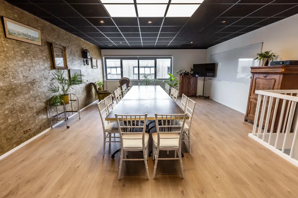 blok opstelling in ruimte met grote ramen en achterin een whitebord