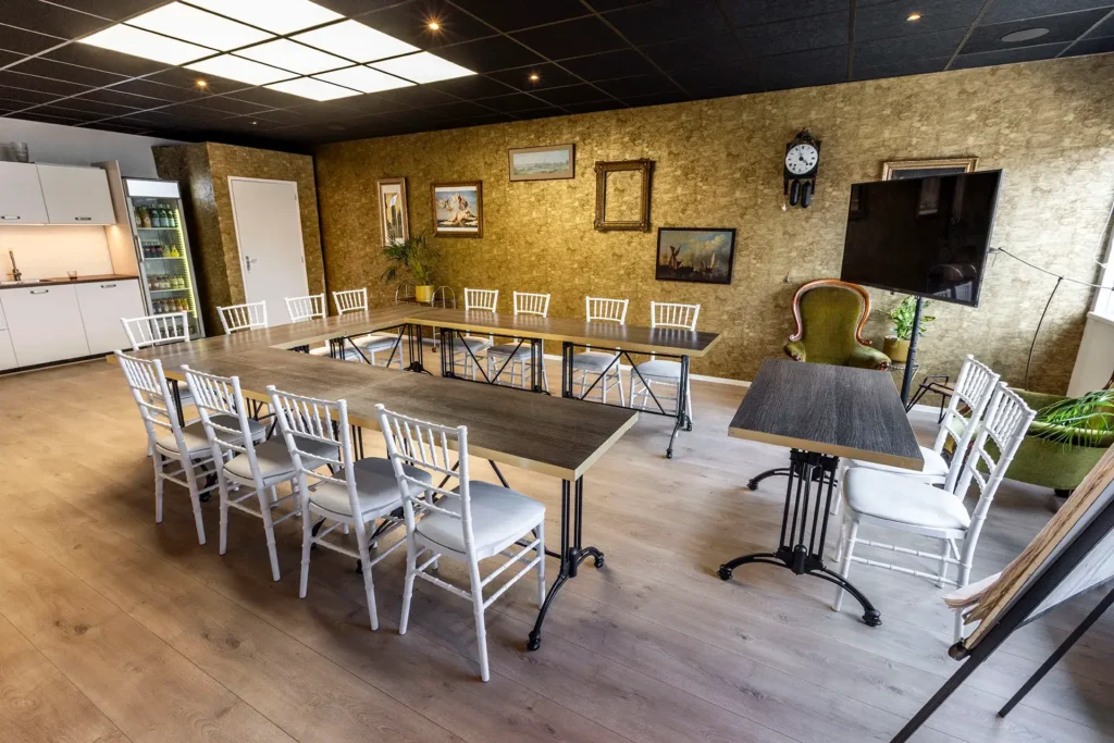 U opstelling met gouden wand, tv en keuken in de achtergrond